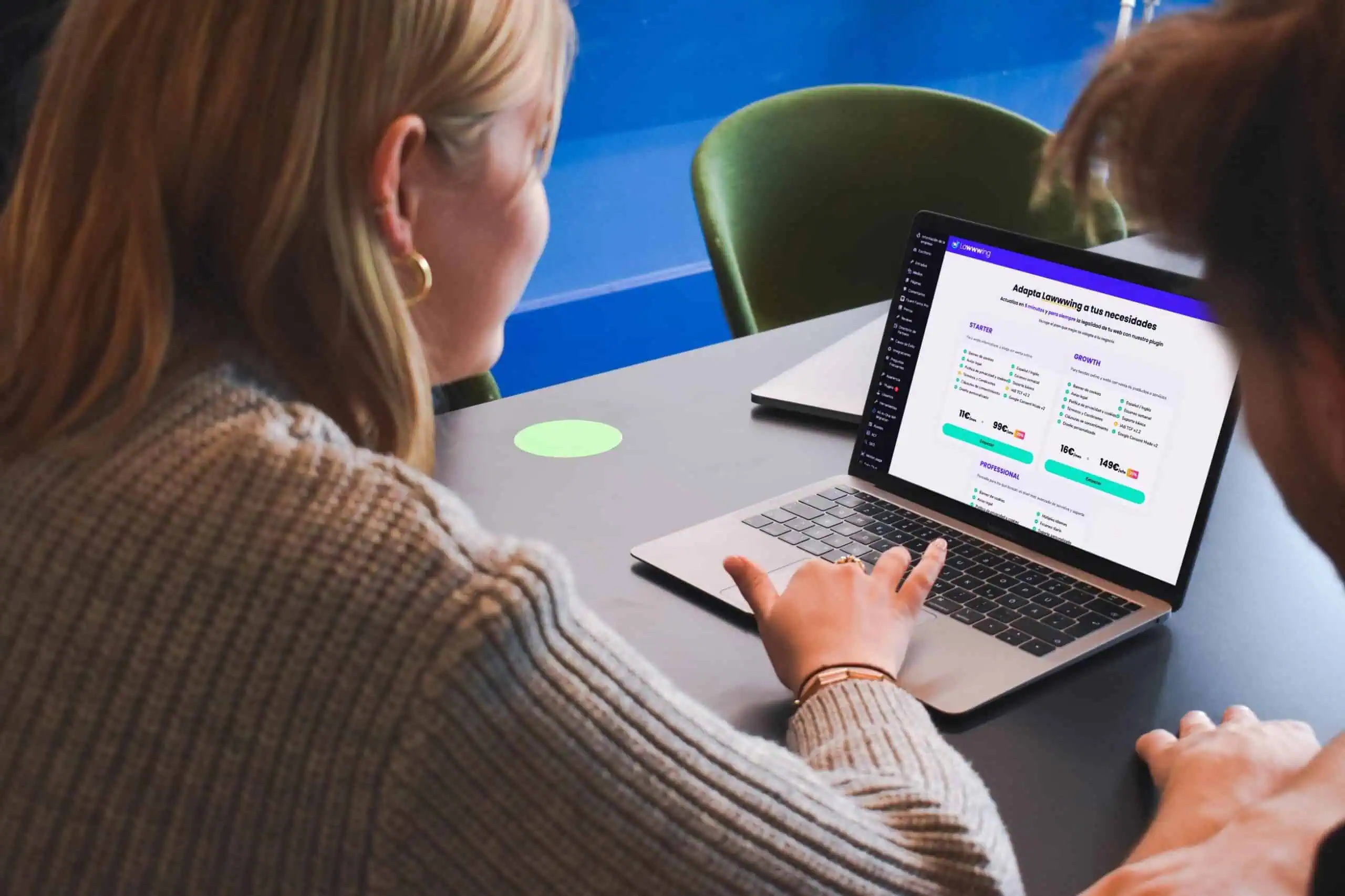 Persona revisando planes de precios y opciones de servicio en un portátil, mientras consulta la plataforma de Lawwwing en un entorno de oficina.