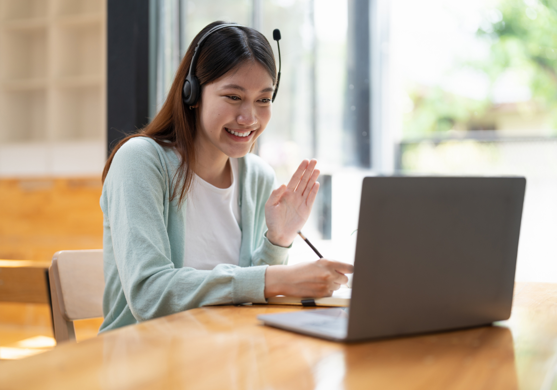 mujer saludando a alumnos online